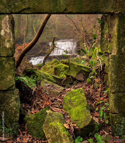 Waterfall observed through the windows of an old mill.