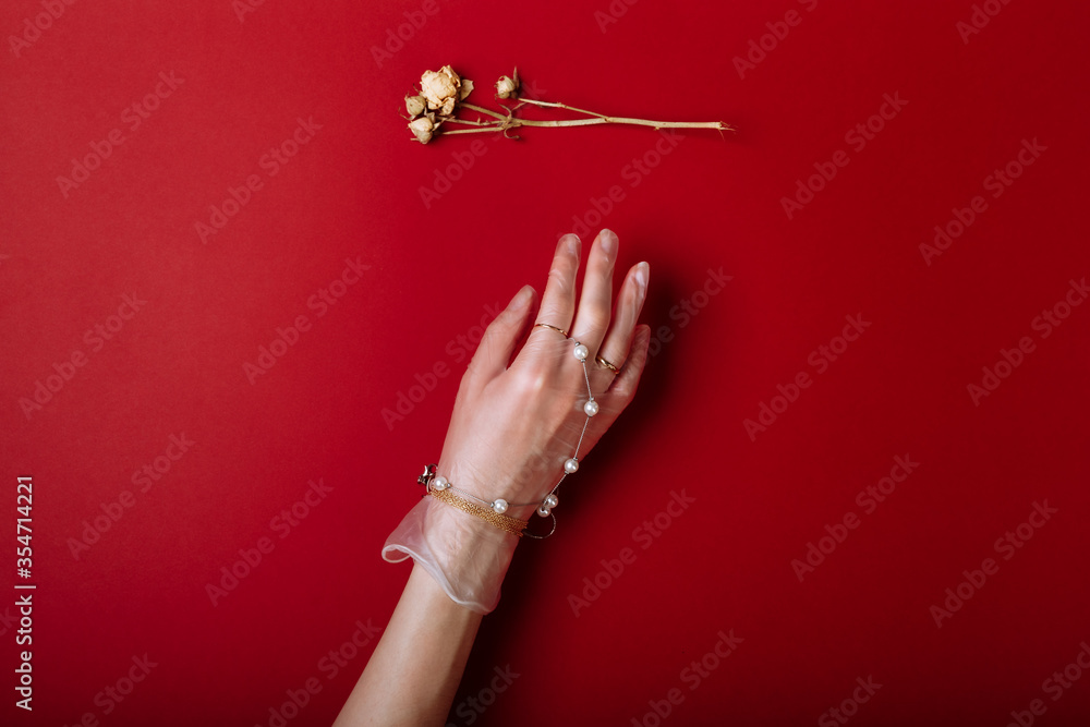 Fashion art hand woman in the glove with Jewelry in summer time and flowers behind her hand with bright contrasting makeup. Creative beauty photo hand skincare - obrazy, fototapety, plakaty 