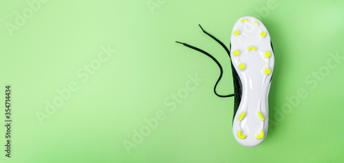 Close-up of the sole of football boots with thorns on green background. Football theme background. Long banner. photo