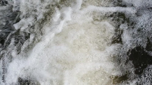 A close-up view of the foaming water from above in slow motion video
