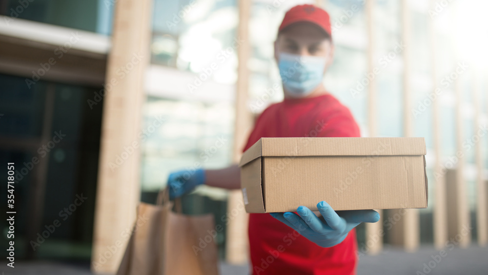 Premium Photo  Young delivery man in medical gloves and