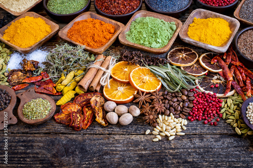 Fototapeta Naklejka Na Ścianę i Meble -  Many colorful spices, herbs and dried fruits on the wooden rustic table
