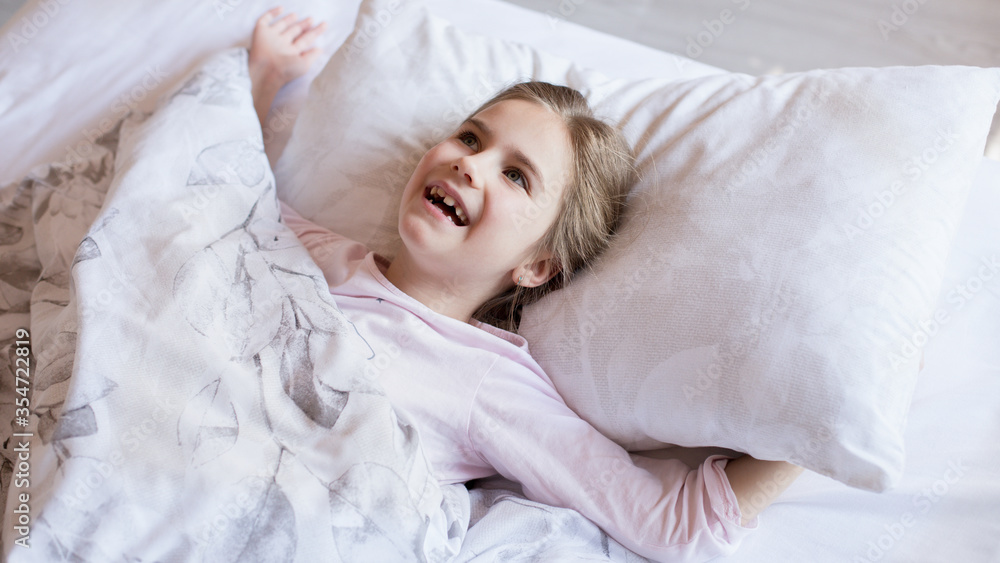 Cute little girl in bed woke up in the morning Cute little girl in bed woke up in the morning