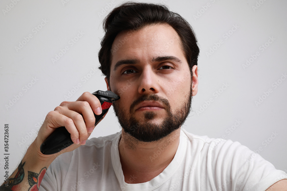 Close-up portrait of bearded man trimmed his hair. Isolated over white background. Close-up portrait of bearded man trimmed his hair. Isolated over white background.