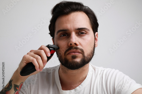 Close-up portrait of bearded man trimmed his hair. Isolated over white background.