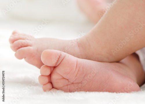 Newborn baby feet on white blanket closeup