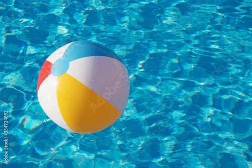 Fotografija Colorful inflatable ball floating in swimming pool
