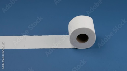 Toilet paper rolls and stops horizontally on a blue background.
