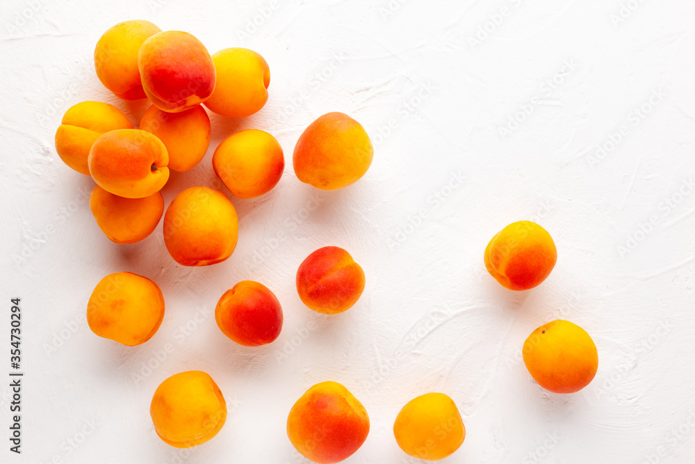 Fresh organic apricots on white background. Vegetarian, clean and healthy eating concept. Flat lay, copy space.