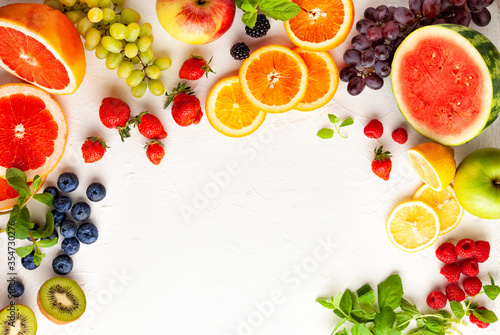 Assorted fresh fruits and berries on white background. Clean eating  healthy life. Top view.