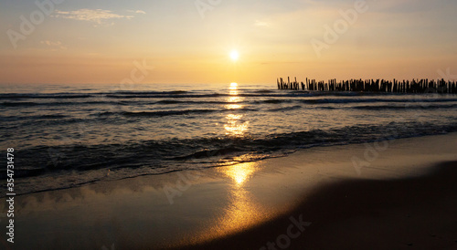 Beautiful sunset on the Baltic Sea, reflected in the sand and water