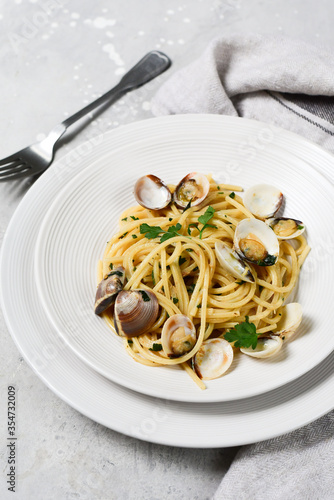 food delivery from restaurants pasta with clams and parsley Spaghetti alle Vongole in white plates on a grey background. recipe food seafood.  top view