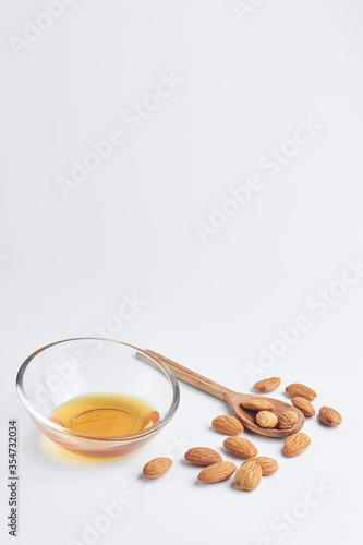 almonds with a wooden spoon and honey in a piala on a white background. healthy food. copy space for text