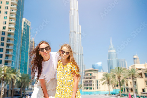 Canvas Print Happy family walking in Dubai with skyscrapers in the background.