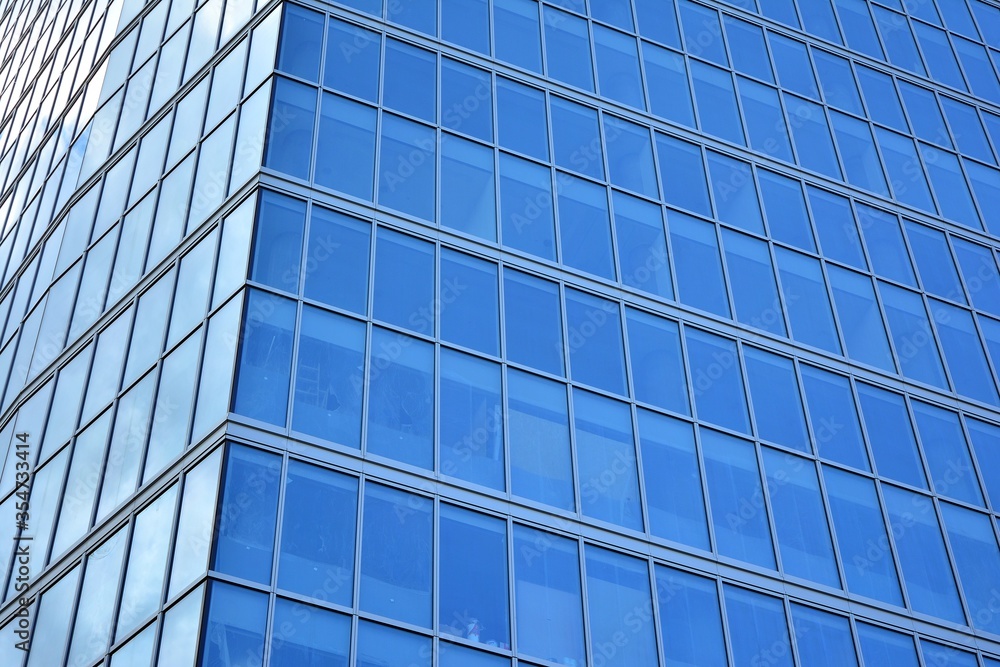 Obraz premium Facade texture of a glass mirrored office building. Fragment of the facade. Modern architecture of the office building.