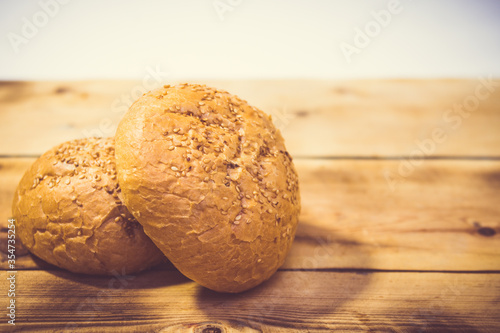 Bun with sesame seeds on a wooden background