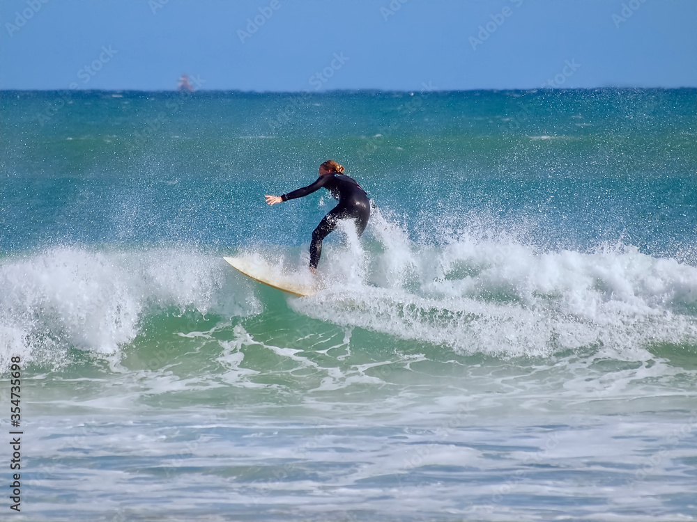 Surfer on his board sporting in the ocean