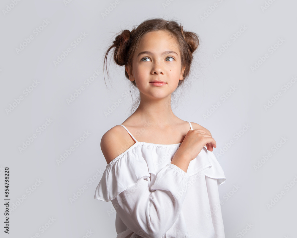 Portrait of a beautiful European blue-eyed girl on a white (light gray) background. Beauty portrait of a teenager. Skin care, natural beauty without makeup. The girl smiles and laughs. Portrait of a beautiful European blue-eyed girl on a white (light gray) background. Beauty portrait of a teenager. Skin care, natural beauty without makeup. The girl smiles and laughs.