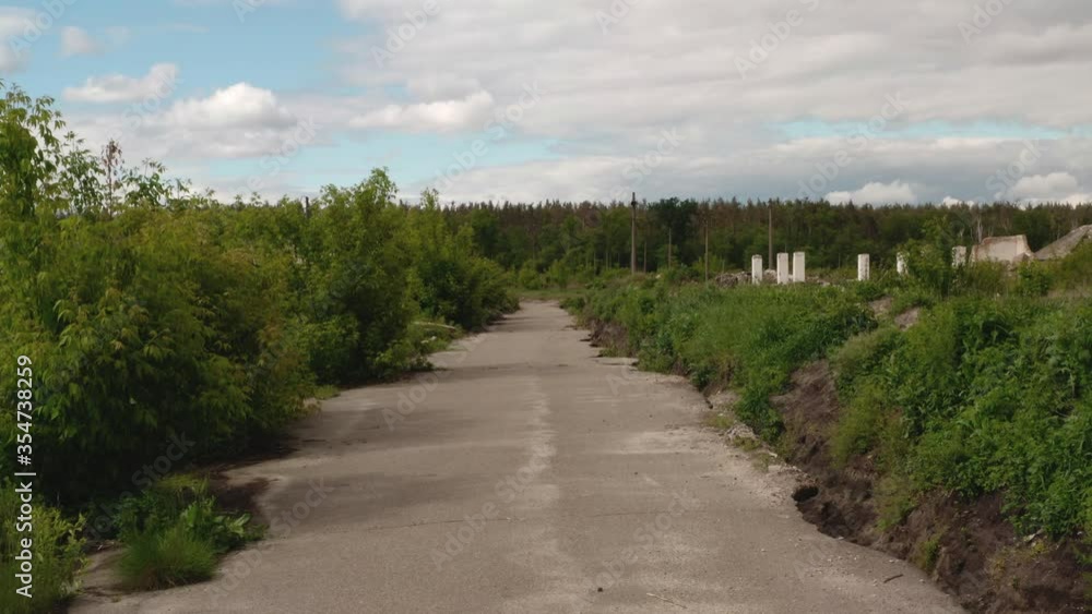Aerial view. Destroyed old abandoned asphalt road on the outskirts of the city. Abandoned area. City landscape on a summer cloudy day Aerial view. Destroyed old abandoned asphalt road on the outskirts of the city. Abandoned area. City landscape on a summer cloudy day