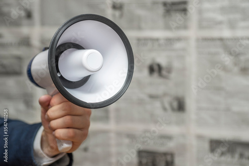 Konstfotografi A man holding a megaphone on background of newspapers