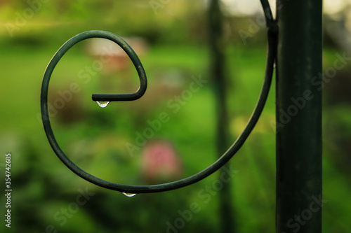 metal wrought iron outdoor element with a transparent drop of rain