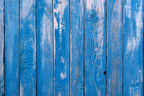 Old blue painted wood wall. Vintage background. Texture of shabby wooden planks with peeling blue paint, rustic wooden house. Picture for wallpapers.