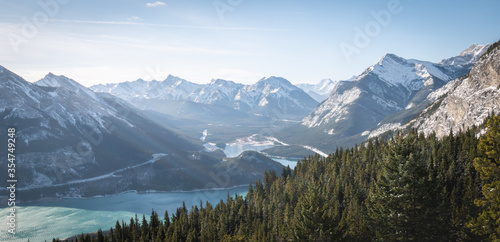 Winter alpine scenery with valley lake and snowy peaks, panoramic shot made in Kananaskis Country, Alberta, Canada
