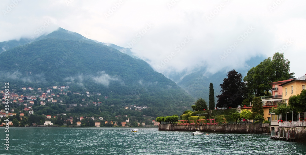 Panoramic view of Como lake with villages and mountains shrouded in clouds. Torno. Italy.