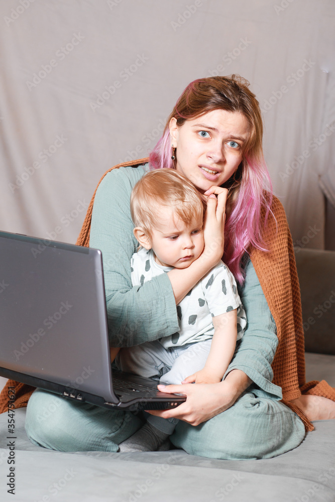 A young woman works at home with a laptop, along with a child.the son wants to communicate with his mother, they make noise and interfere with work.isolation during the coronovirus pandemic A young woman works at home with a laptop, along with a child.the son wants to communicate with his mother, they make noise and interfere with work.isolation during the coronovirus pandemic