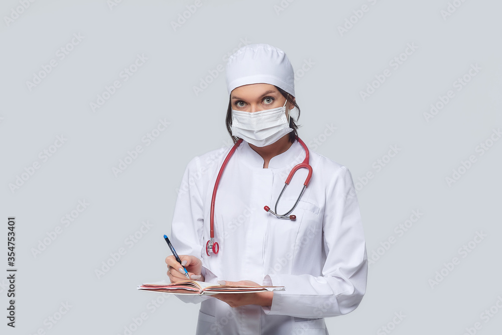 Medical concept of a female doctor in a white coat with a stethoscope, doctor. A female hospital worker looks at the camera and smiles, Studio, White background Medical concept of a female doctor in a white coat with a stethoscope, doctor. A female hospital worker looks at the camera and smiles, Studio, White background