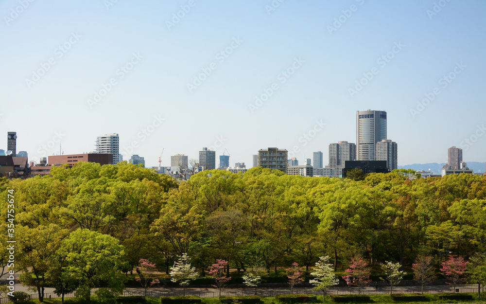 City view with green trees front and with building back in Osaka