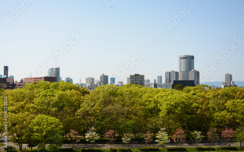 City view with green trees front and with building back in Osaka