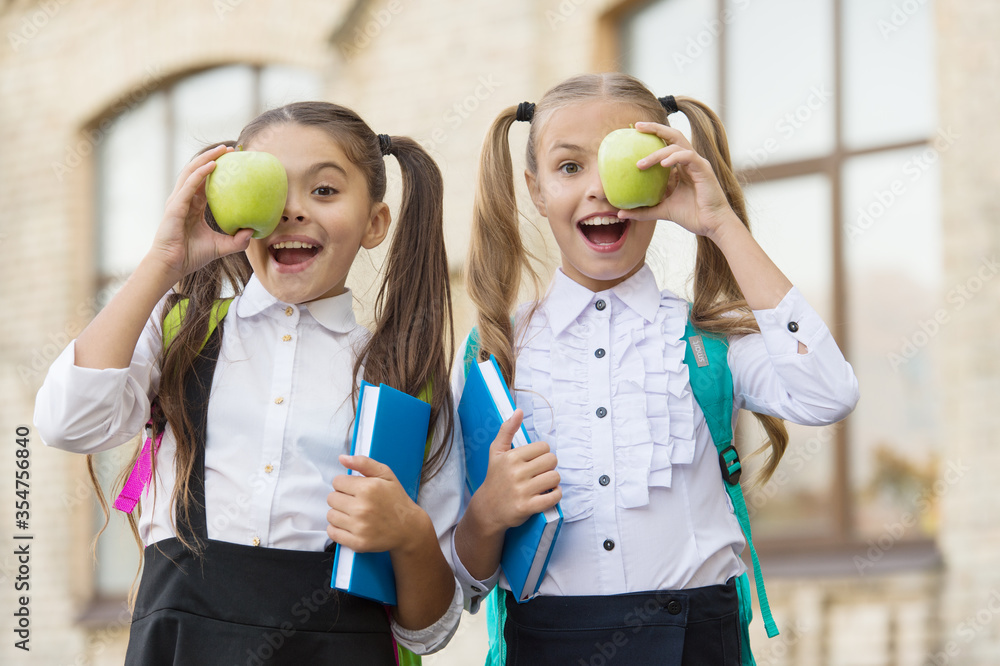 That is great. lunch time at school break. happy kids in uniform. learning subject together. modern education for girls. book reading. concept of friendship. little pupil with notebook and apple That is great. lunch time at school break. happy kids in uniform. learning subject together. modern education for girls. book reading. concept of friendship. little pupil with notebook and apple