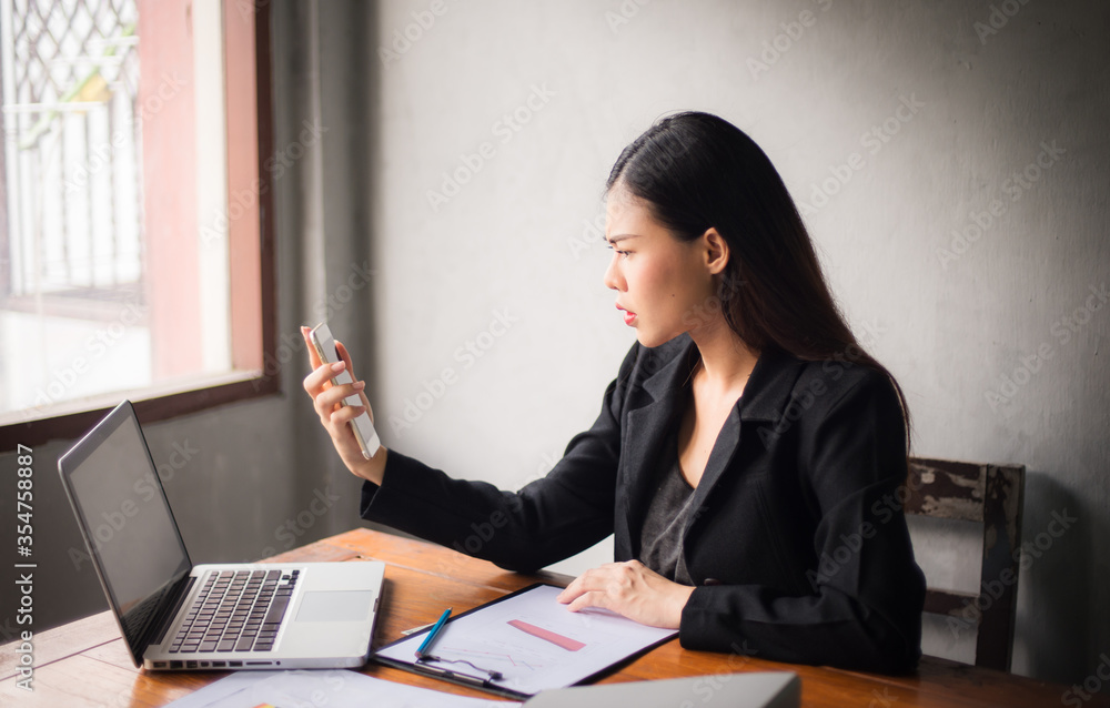 Office time, Asian young woman working in office With stress and business communication through mobile phones, executives, business women Office time, Asian young woman working in office With stress and business communication through mobile phones, executives, business women
