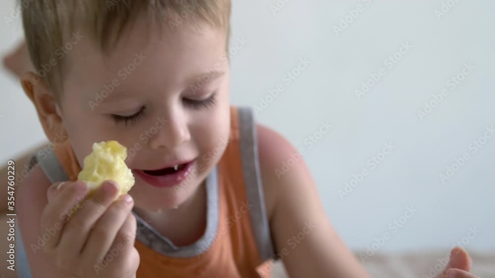child boy eat apple and watch smartphone on bed at home. distance learning education child boy eat apple and watch smartphone on bed at home. distance learning education