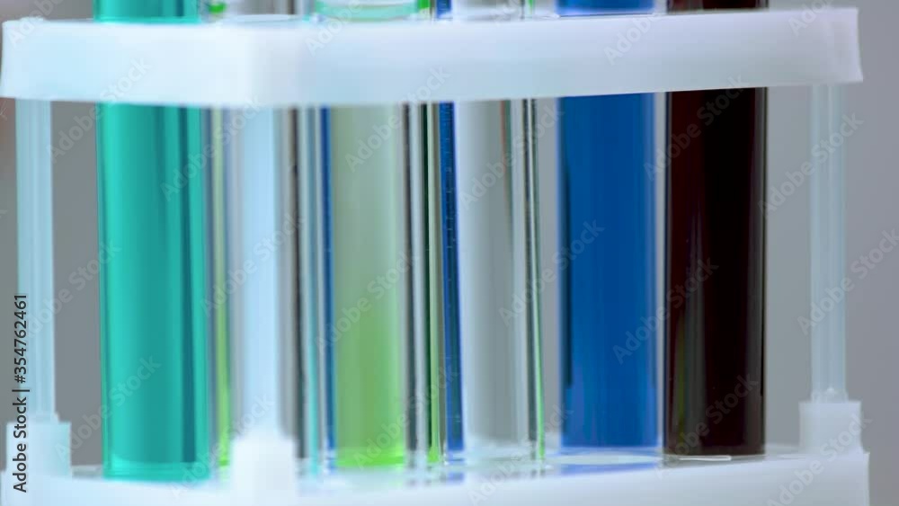 Laboratory equipment being filled with red liquid. Science test tubes with blue and red fluid close up. Research in clinical laboratory. Laboratory equipment being filled with red liquid. Science test tubes with blue and red fluid close up. Research in clinical laboratory.