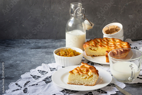 A slice of homemade pie with cottage cheese, raisins and milk, in a rustic style.