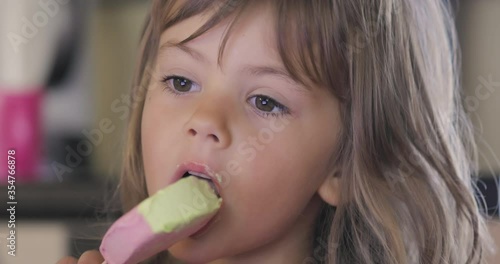 Adorable little girl licking ice cream photo