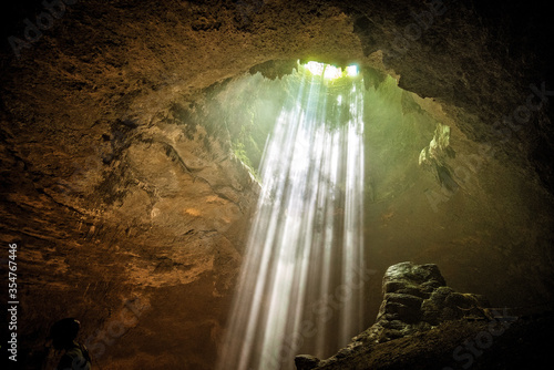 rays of light shine through at Jomblang cave near Yogyakarta, Indonesia photo