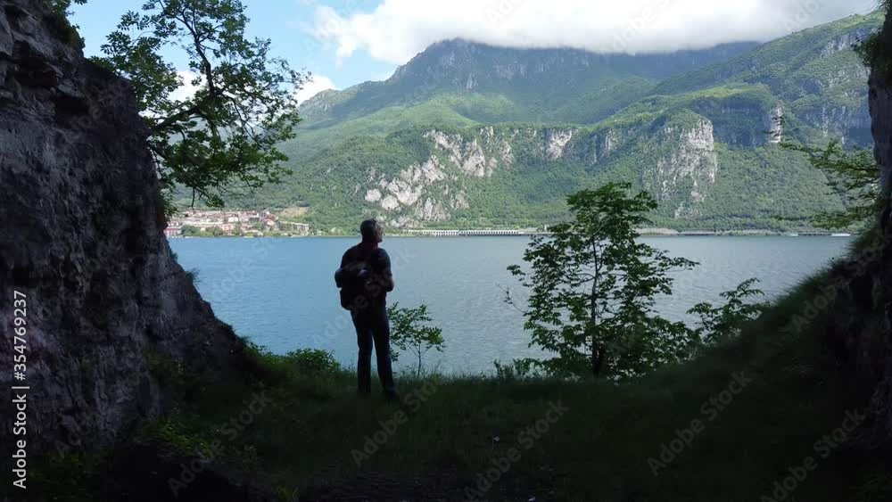 Hiker exploring cave near lake, Como, Italy Hiker exploring cave near lake, Como, Italy
