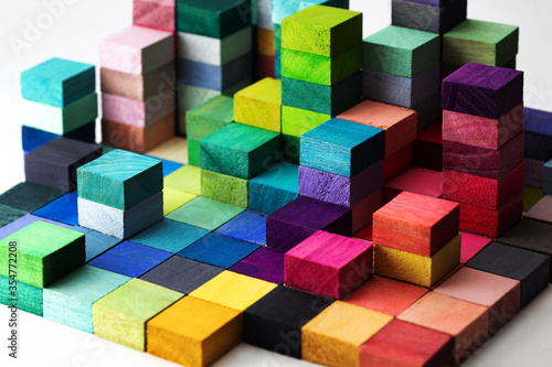 Spectrum of stacked multi-colored wooden blocks. Background or cover for something creative, diverse, expanding,  rising or growing. photo