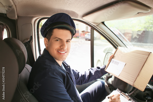 Handsome young postman in car