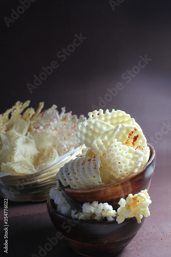 Homemade sundried potato chips and sago wafers.Deepfried and served in wooden bowl.