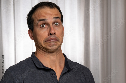 Mature man (44 years old) pulling a funny face of surprise with wide eyes. photo