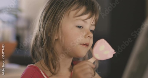 Adorable little girl licking ice cream