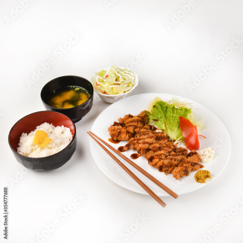 Traditional japanese sushi pieces placed between chopsticks, separated on white background.