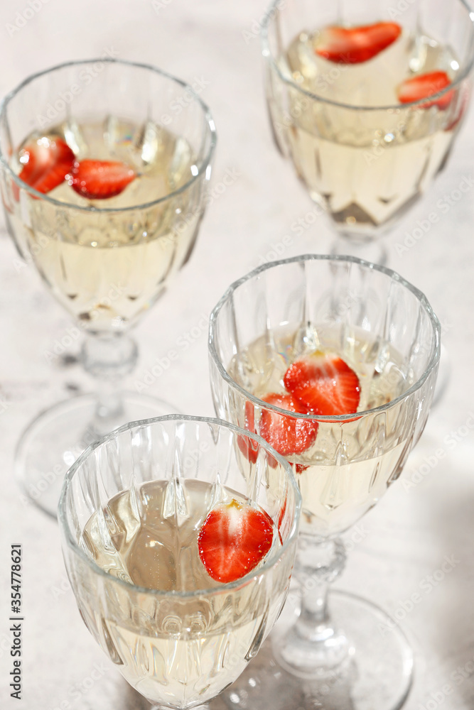 Glasses of tasty champagne with strawberry on table Glasses of tasty champagne with strawberry on table