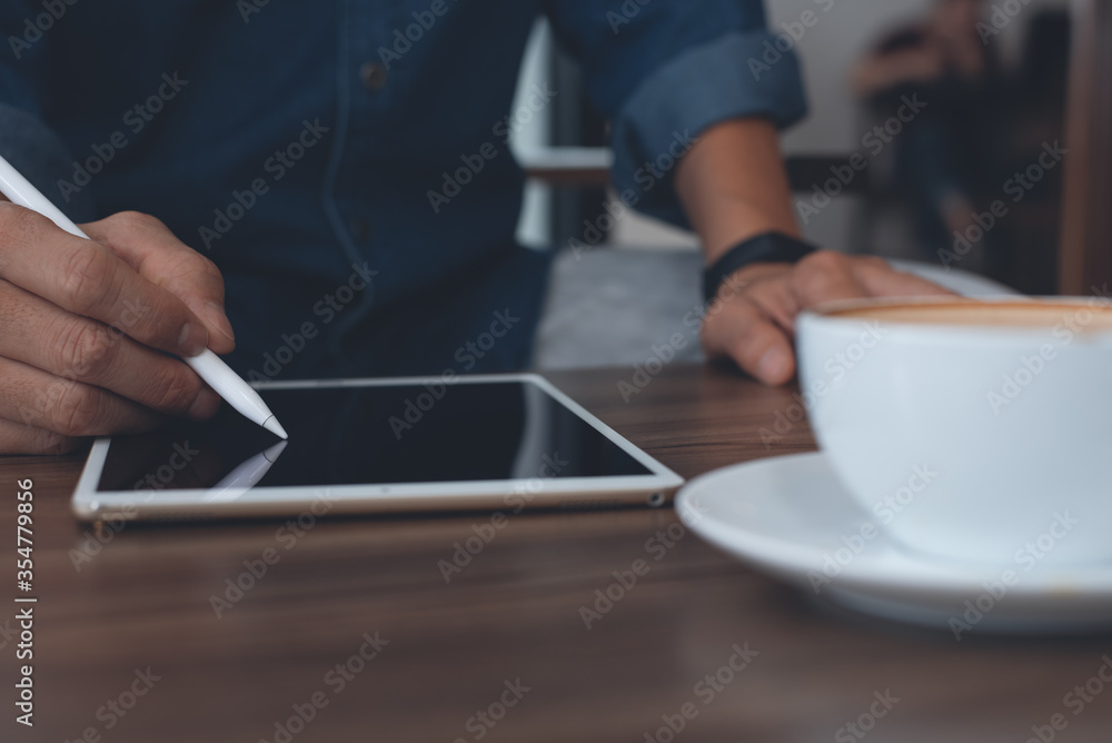 Casual man or graphic designer working on digital tablet in coffee shop Casual man or graphic designer working on digital tablet in coffee shop