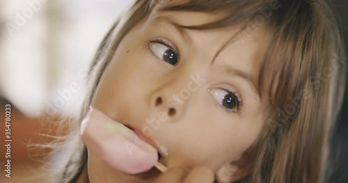 Adorable little girl licking ice cream