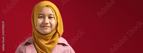 Portrait of young happy confident muslim teenage girl wearing hijab looking at camera and smiling cheerfully © airdone